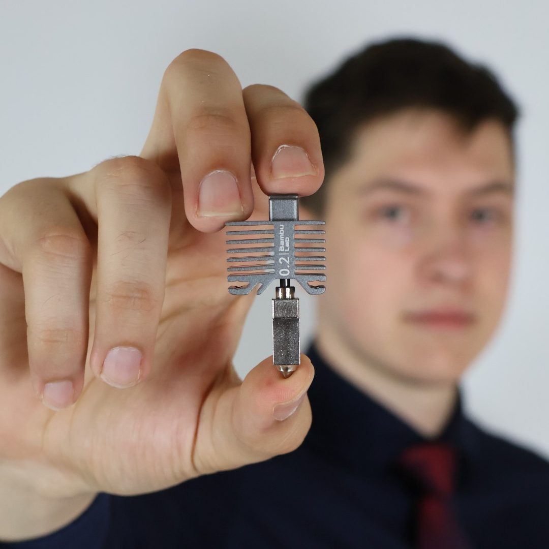 Stahl Hotend für Carbonfaser Druck Junger Mann hält eine Hotend in die Kamera.